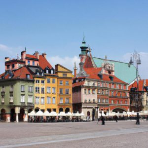 Zbliżenie na montaż gąsienicy do koła quada w domowym garażu, widoczne ręce dokręcające śruby prostymi narzędziami.